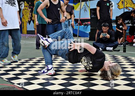 Bgirl Chair Freeze Breakdance Move während eines Wettkampfs auf den Basketballplätzen von Woolloomooloo, Sydney Stockfoto