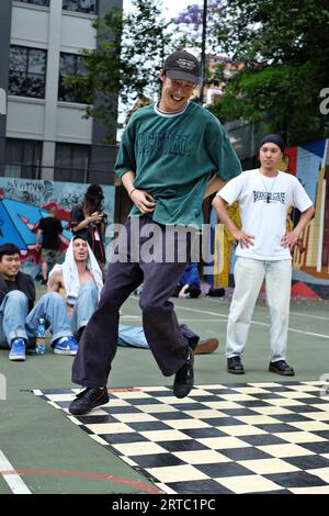 Ein großer männlicher Tänzer in Baggy Hip Hop Gear, der bei einem Breakdance- und Battles-Wettbewerb auf den Basketballfeldern von Woolloomooloo, Sydney, tanzt Stockfoto