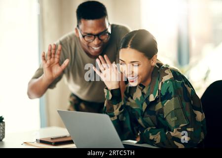 Soldat, Frau und Mann winken auf Laptop für Kommunikation, Videoanrufe und Glück im Wohnzimmer zu Hause. Computer, Digital und Menschen im Militär Stockfoto