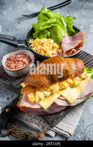 Croissant Sandwich mit truthahnschinken, Rührei, Käse und Salat. Grauer Hintergrund. Draufsicht. Stockfoto