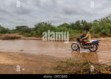 OMO VALLEY, ÄTHIOPIEN - 4. FEBRUAR 2020: Motorrad auf einer matschigen Straße im Omo Valley, Äthiopien Stockfoto