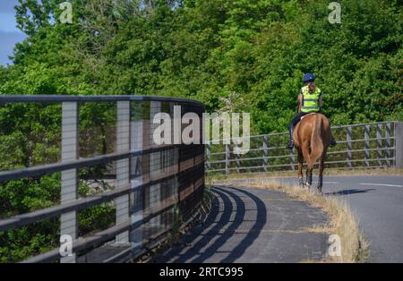 Pferd und Reiter überqueren eine Straßenbrücke über die Autobahn M40, Warwickshire, England. Stockfoto