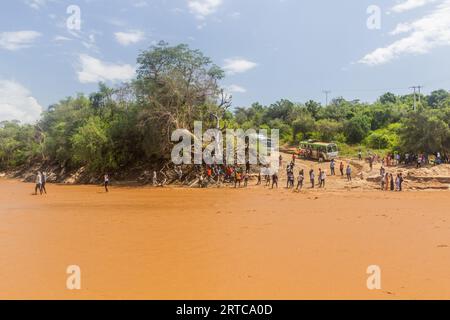 OMO VALLEY, ÄTHIOPIEN - 4. FEBRUAR 2020: Menschen überqueren den Kizo-Fluss in Äthiopien Stockfoto