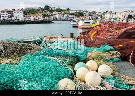 Töpfe, Netze und Fischerboote in einem kantabrischen Hafen. Stockfoto