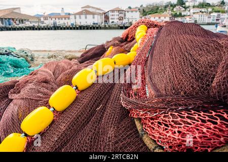 Töpfe, Netze und Fischerboote in einem kantabrischen Hafen. Stockfoto