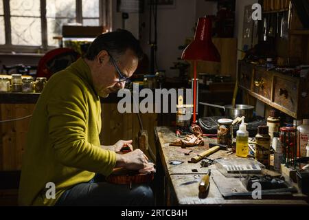 Lutist Philippe Devanneaux arbeitete in seinem Geschäft in Cremona, Italien Stockfoto