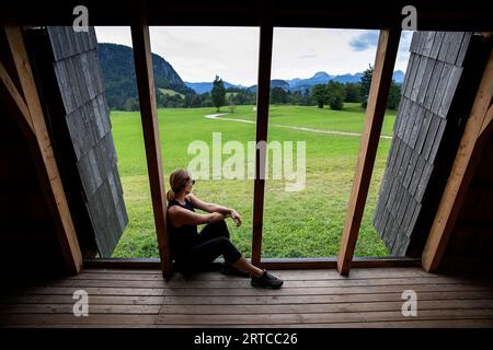 Mountainbiker, der sich in einem wunderschönen Holzdach auf einer Radroute in der Nähe des Bohinj-Sees im Triglav-Nationalpark, Slowenien, entspannt Stockfoto