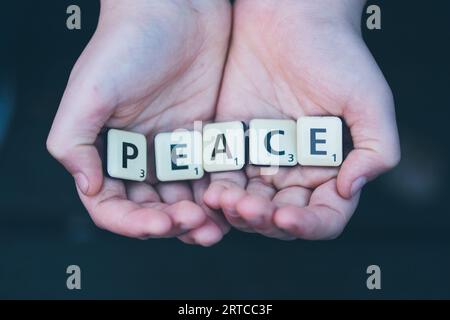 Gouda, Niederlande, Zeichen des Friedens in Kinderhand, Scrabble-Buchstaben Stockfoto