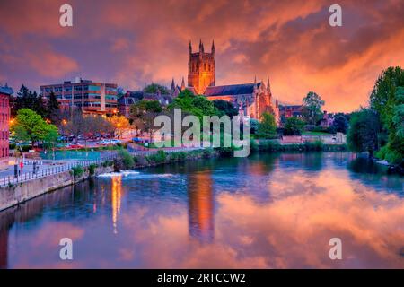 Die Kathedrale von Worcester erleuchtet in der Dämmerung mit Sonnenuntergang und Reflexion am Fluss Severn Stockfoto