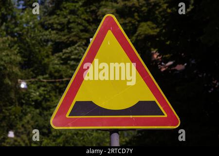 Ein dreieckiges Straßenschild, das auf das Vorhandensein von Unebenheiten hinweist. Stockfoto