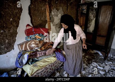 Al Haouz, Marokko. September 2023. Zahra, 60 Jahre alt, inspiziert ihr beschädigtes Haus in Asni Town nach dem starken Erdbeben, das Marokko am späten Freitag heimsuchte. Quelle: Khaled Nasraoui/dpa/Alamy Live News Stockfoto