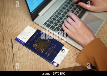 Frau mit britischem Pass wartet auf ihren Flug. Stockfoto