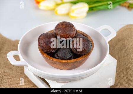 Unniyappam oder Unni appam: Traditioneller, frittierter kerala-Snack mit Reis, trockenem Kokosnuss-Ghee, Unniyappam in einer Holzschale isoliert Stockfoto