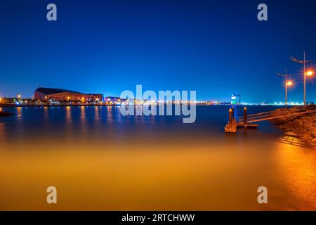 Blick auf die Skyline der Stadt von der Strandbrücke. Gebäude und Ufer sichtbar. Nachtblick auf Kuwait Stadt und Lichter Stockfoto