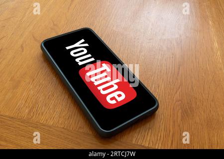 London, Großbritannien, 5. September 2023:- Ein Mobiltelefon auf einem Holztisch mit einem Youtube-Logo Stockfoto