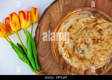 Malabar parota im isolierten Hintergrund. Südindische Porata in einem Holzteller und dekoriert und isoliert. Auch Nool porata genannt, Roti Parata Stockfoto