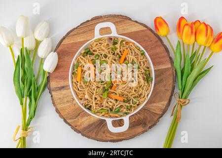 Leckere Gemüse-hakka-Nudeln auf weißem Teller und isoliertem Hintergrund. Indo-chinesisches vegetarisches Gericht. Indische Gemüse-Nudeln mit Gemüse. Stockfoto