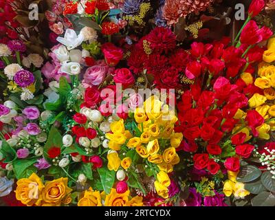 Mehrfarbige künstliche Blumen, die für die Dekoration des Diwali-Festivals verwendet werden und in einem Geschäft am Tag vor dem Diwali- und Ganesh-Festival hängen Stockfoto