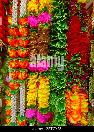 Mehrfarbige künstliche Blumen, die für die Dekoration des Diwali-Festivals verwendet werden und in einem Geschäft am Tag vor dem Diwali- und Ganesh-Festival hängen Stockfoto