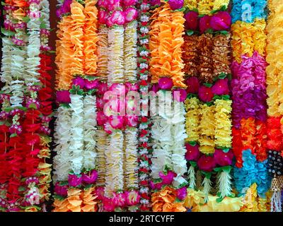 Mehrfarbige künstliche Blumen, die für die Dekoration des Diwali-Festivals verwendet werden und in einem Geschäft am Tag vor dem Diwali- und Ganesh-Festival hängen Stockfoto