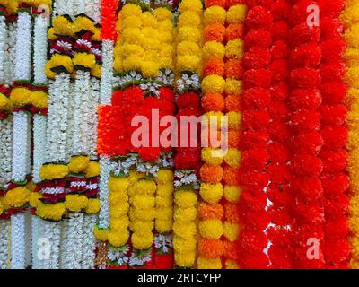 Mehrfarbige künstliche Blumen, die für die Dekoration des Diwali-Festivals verwendet werden und in einem Geschäft am Tag vor dem Diwali- und Ganesh-Festival hängen Stockfoto