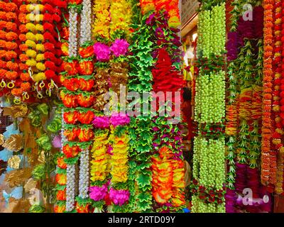 Mehrfarbige künstliche Blumen, die für die Dekoration des Diwali-Festivals verwendet werden und in einem Geschäft am Tag vor dem Diwali- und Ganesh-Festival hängen Stockfoto