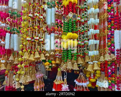 Mehrfarbige künstliche Blumen, die für die Dekoration des Diwali-Festivals verwendet werden und in einem Geschäft am Tag vor dem Diwali- und Ganesh-Festival hängen Stockfoto