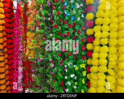 Mehrfarbige künstliche Blumen, die für die Dekoration des Diwali-Festivals verwendet werden und in einem Geschäft am Tag vor dem Diwali- und Ganesh-Festival hängen Stockfoto