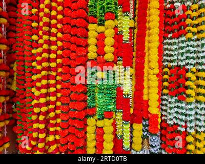 Mehrfarbige künstliche Blumen, die für die Dekoration des Diwali-Festivals verwendet werden und in einem Geschäft am Tag vor dem Diwali- und Ganesh-Festival hängen Stockfoto