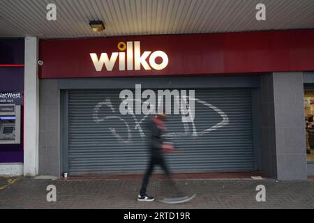 Ein Mann geht am letzten Handelstag vorbei an dem geschlossenen Wilko-Laden in Barking im Osten Londons und einem der ersten Wilko-Geschäfte, die geschlossen wurden, als der dramatische Zusammenbruch der High-Street-Kette Gestalt annimmt. Der historische Einzelhändler wird in der ersten Phase der Schließung 24 Geschäfte in ganz Großbritannien schließen, und Hunderte von Mitarbeitern in den Geschäften werden entlassen. Bilddatum: Dienstag, 12. September 2023. Stockfoto
