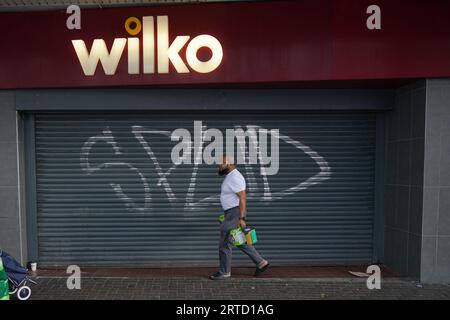 Ein Mann geht am letzten Handelstag vorbei an dem geschlossenen Wilko-Laden in Barking im Osten Londons und einem der ersten Wilko-Geschäfte, die geschlossen wurden, als der dramatische Zusammenbruch der High-Street-Kette Gestalt annimmt. Der historische Einzelhändler wird in der ersten Phase der Schließung 24 Geschäfte in ganz Großbritannien schließen, und Hunderte von Mitarbeitern in den Geschäften werden entlassen. Bilddatum: Dienstag, 12. September 2023. Stockfoto