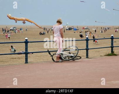 Eine junge Dame stürzt mit dem Fahrrad auf den Boden, St Annes Beach, Lytham St Annes, Lancashire, Vereinigtes Königreich, Europa am Sonntag, 10. September 2023 Stockfoto