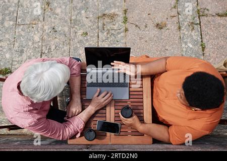 Blick von oben auf zwei Senioren bei Geschäftstreffen im Café im Freien Stockfoto