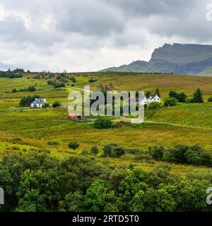 Grüne Landschaft mit hohen Bergen und Hütten auf der Isle of Skye, Schottland, Großbritannien. Stockfoto