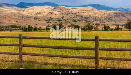 Light Before a Storm auf Farmen im Südwesten von Montana mit der Gallatin-Bergkette und dem Nationalwald in der Ferne. Getreide- und Heuanbau. Stockfoto