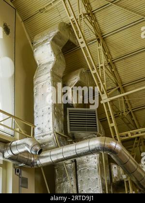 Thermisch isolierte Elemente der Lüftungs- und Heizungsanlage in einem großen Hangar Stockfoto