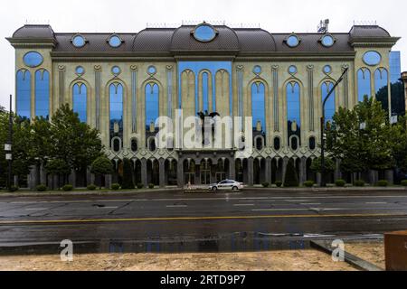 Das Simon Janashia National Museum of Georgia befindet sich an der Shota Rustaveli Avenue gegenüber dem georgianischen Parlamentsgebäude. Eine Statue eines Adlers ziert die Fassade. Ein Polizeiauto parkt auf der Straße in Tiflis, Georgien Stockfoto