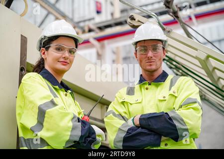 Industriearbeiter in der Fabrik. Junger Techniker mit orangem Schutzhelm. Kluger kaukasischer Fabrikarbeiter, der einen Hut trägt und im Kraftwerk arbeitet Stockfoto