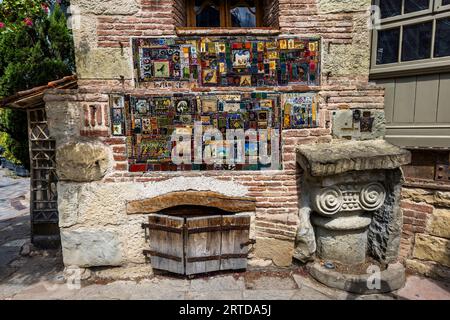 Eingangsbereich des Marionettentheaters Gabriadze in der Altstadt von Tiflis: Bunte Mosaiken aus Keramikfragmenten, gefundene Objekte und Glasstücke bedecken die Backsteinwände des Theatergebäudes. Der georgianische Künstler Rezo Gabriadze ließ den Komplex ab den 1980er Jahren mit Materialien aus abgerissenen Häusern errichten; das Theater ist berühmt für seinen Uhrenturm mit seiner Carillonfigur. Ioan Shavteli Lane, Kala, Ortachala, Bezirk Krtsanisi, Tiflis, 0108, Georgien Stockfoto