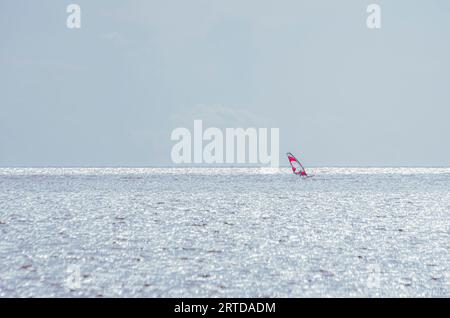 Einsamer Windsurfer auf dem fernen offenen Meer, Kalmarsund in der Nähe des Dorfes Färjestaden, Öland Island, Schweden. Stockfoto