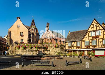 Brunnen Fontaine de Saint-Léon und St.-Leo-Kapelle in Eguisheim, Elsass, Frankreich | Fontaine de Saint-Léon und Chapelle Saint-Léon in EG Stockfoto