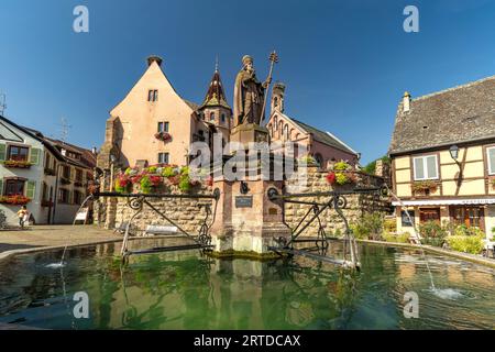 Brunnen Fontaine de Saint-Léon und St.-Leo-Kapelle in Eguisheim, Elsass, Frankreich | Fontaine de Saint-Léon und Chapelle Saint-Léon in EG Stockfoto