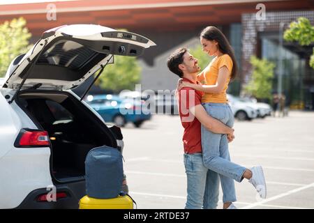Liebender gutaussehender tausendjähriger Mann, der seine schöne Freundin am Flughafen trifft Stockfoto