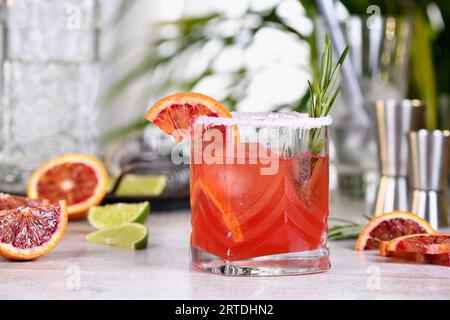 Roter sizilianischer Orange Paloma Cocktail mit Tequila, frischer Limette und Rosmarin mit rotem sizilianischem Orangensaft. Dieser Cocktail ist voller heller Zitrusaromen Stockfoto