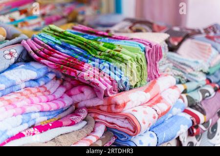 Bunte Handtücher auf der Theke eines Handelszeltes auf einer Messe. Nahaufnahme. Stockfoto