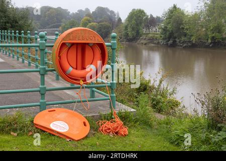 Beschädigte Schutzhülle für Rettungsring im Dock Park, Dumfries Stadtzentrum, Schottland. Der Fluss Nith liegt im Hintergrund. Stockfoto