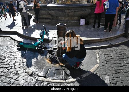 Eine Frau füllt eine Wasserflasche aus einem Nasone (Wasserbrunnen) in Rom, Italien, Oktober 31 2022 Stockfoto