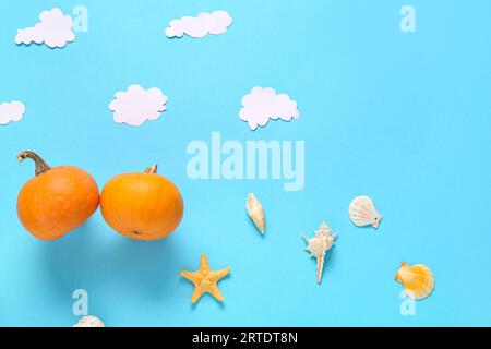 Komposition mit Halloween Kürbissen und Muscheln auf blauem Hintergrund Stockfoto