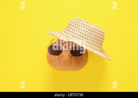 Halloween Kürbis mit Strandaccessoires auf gelbem Hintergrund Stockfoto