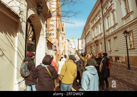 Krakau, Polen - 6. märz 2023: Reiseleiter mit Reisegruppe auf dem Hauptplatz in Krakau. Kostenlose Touristenwanderungen mit Einheimischen. Einzigartiges Erlebnis in New Cit Stockfoto